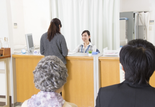入院手続きの案内を受ける患者と家族